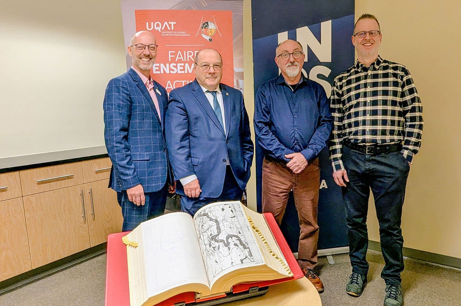 De gauche à droite : M. Vincent Rousson, recteur de l’UQAT, M. Luc-Alain Giraldeau, directeur général de l’INRS, M. François Cartier, archiviste à l’INRS et M. Francis Lévesque, directeur de l’École d’études autochtones et professeur à l’UQAT, lors de la remise officielle tenue au campus de l’UQAT à Val-d’Or, le 6 novembre 2025